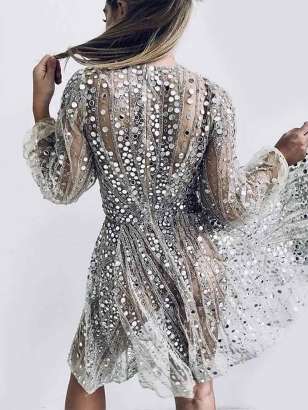 Silver sequin mini dress with balloon sleeves and a-line cut, featuring a sheer overlay.