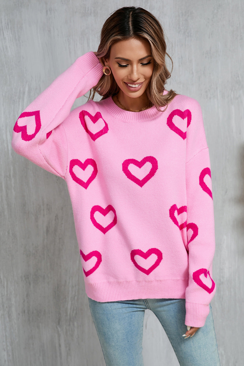 Fuchsia pink acrylic knit pullover sweater with allover heart intarsia pattern.