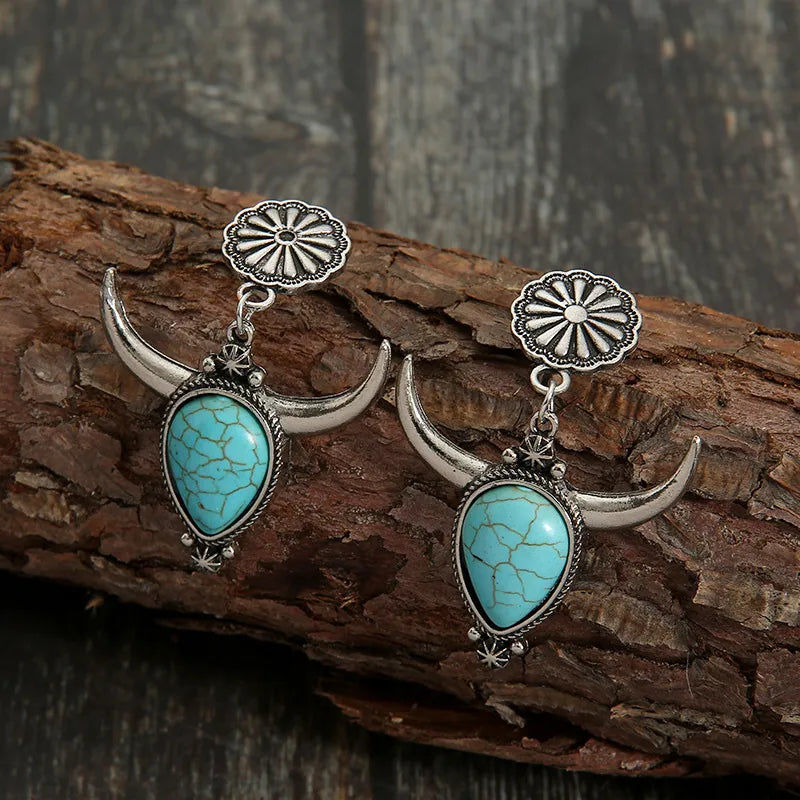 Southwestern crescent drop earrings with turquoise stones and silver bull horns.