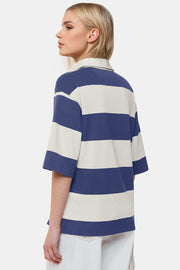 Oversized rugby polo shirt with blue and cream stripes, a classic collar, and short sleeves.