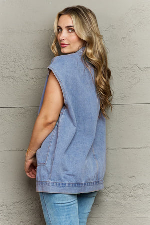 Light wash denim utility vest with collared neck and oversized pockets.