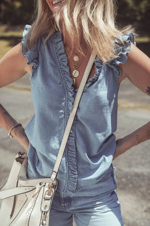 Chambray sleeveless blouse with ruffle trim and V-neck.
