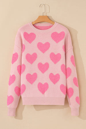 Blush pink knit sweater with allover textured heart motif and crewneck.