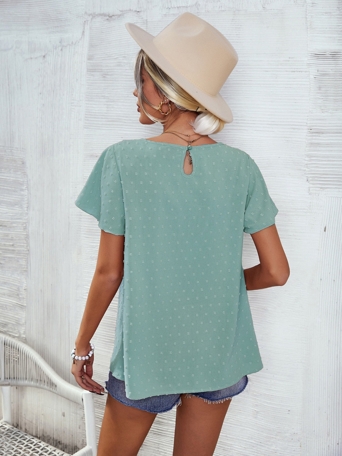 Light green Swiss dot blouse with flutter sleeves and keyhole back detail.