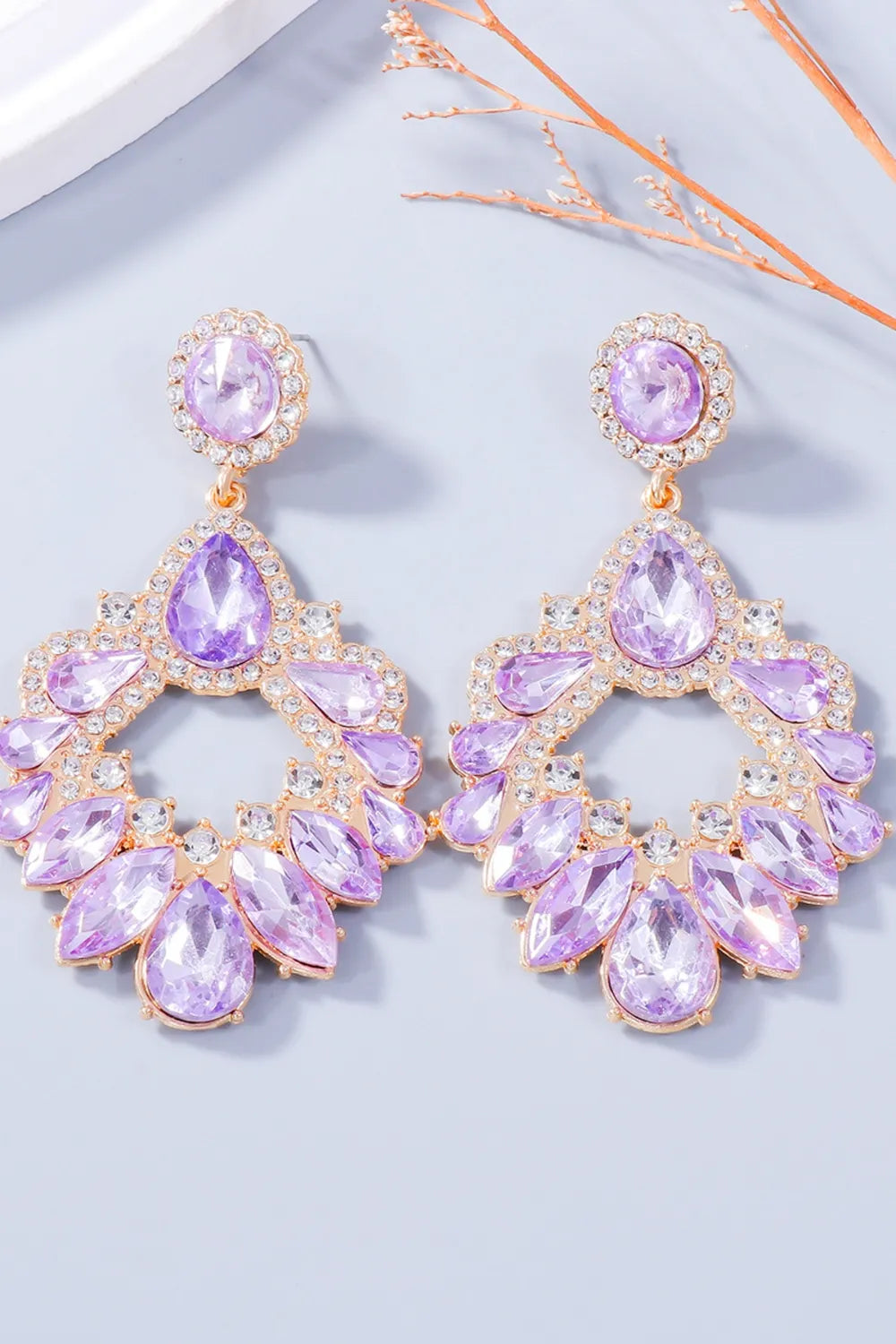 Floral-inspired drop earrings with purple crystals and gold alloy setting.