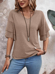 Mocha jersey tee with tiered short sleeves and V-neck, styled with jeans and necklace.