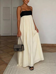 Elegant two-tone maxi dress with spaghetti straps, black bodice and cream skirt.
