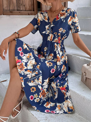 Blue midi dress with vibrant floral pattern, V-neck, short sleeves, and elastic waist.
