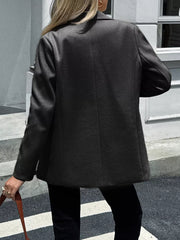 Chic lapel blazer in black with buttoned front and practical pockets, shown from the back.