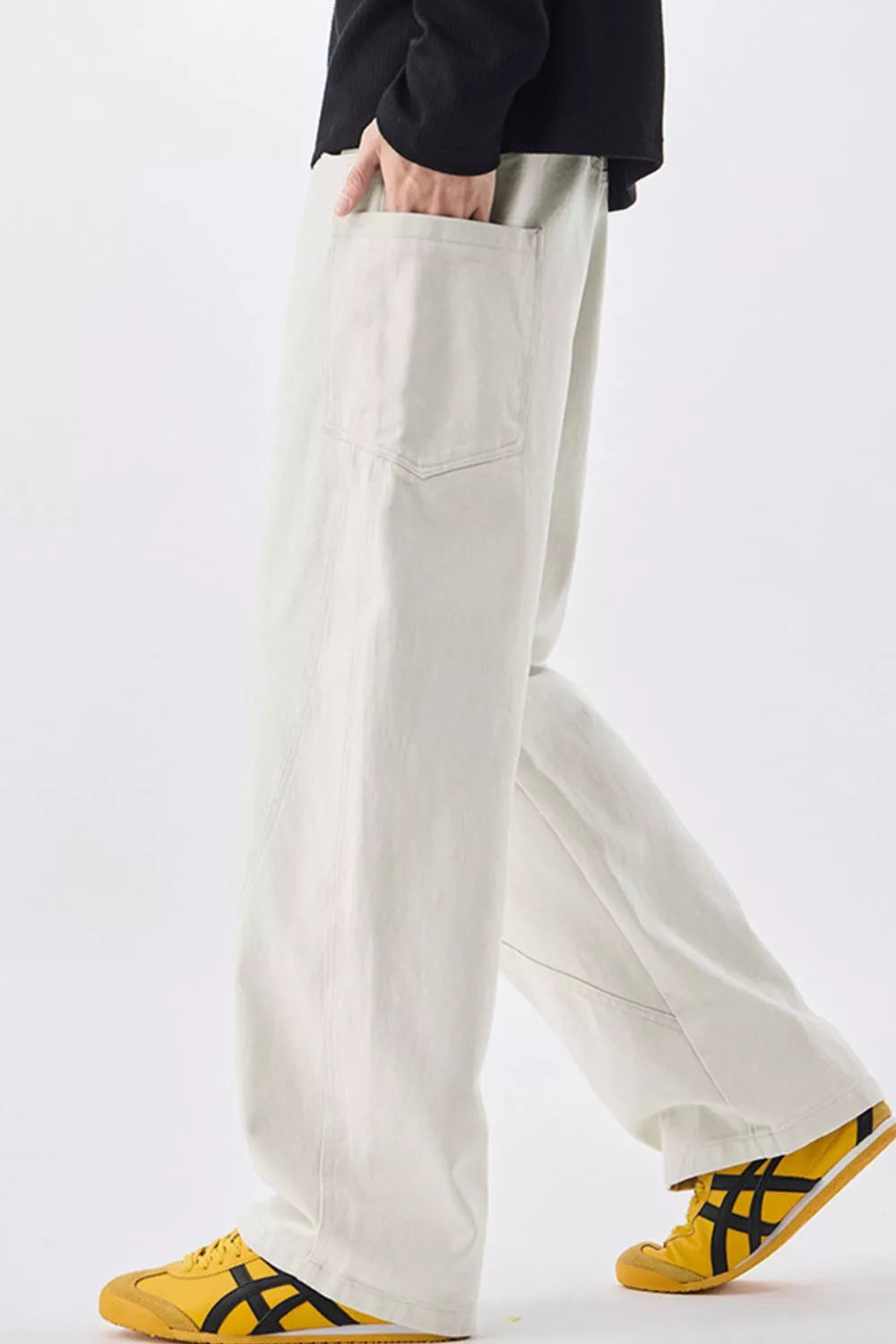 Men's relaxed fit off-white cotton jeans with drawstring waist and visible pocket detail.