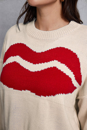 Cream knit sweater with large red lips graphic and distressed hem detail.