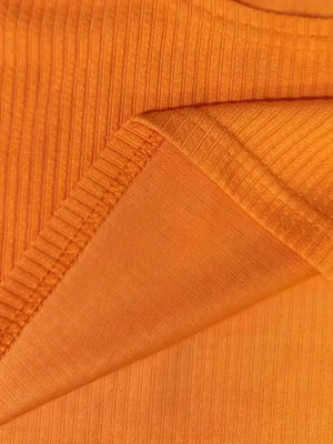 Orange ribbed knit crop top detail showing texture and seam.