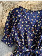 Dark blue floral v-neck midi dress with button front and belted waist.