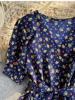 Dark blue floral v-neck midi dress with button front and belted waist.