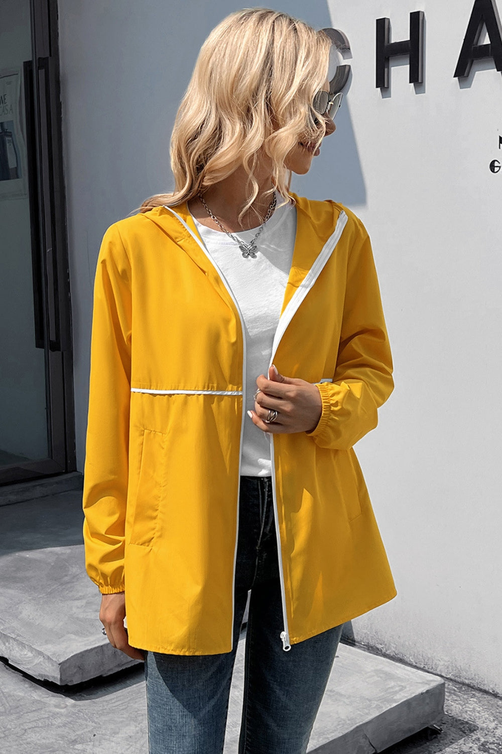 Yellow hooded rain jacket with white trim and zipper, casual waterproof outerwear