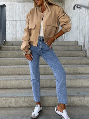 Camel faux leather bomber jacket with sculpted sleeves and flap pockets, styled with jeans.