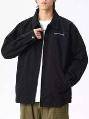 Men's black casual zip-up jacket with embroidered text detail on chest.