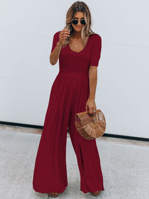 Burgundy textured wide-leg jumpsuit with subtle waist and short sleeves.