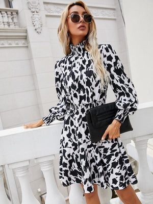 Women's multicolor abstract print midi dress with shirred waist and mock neck.