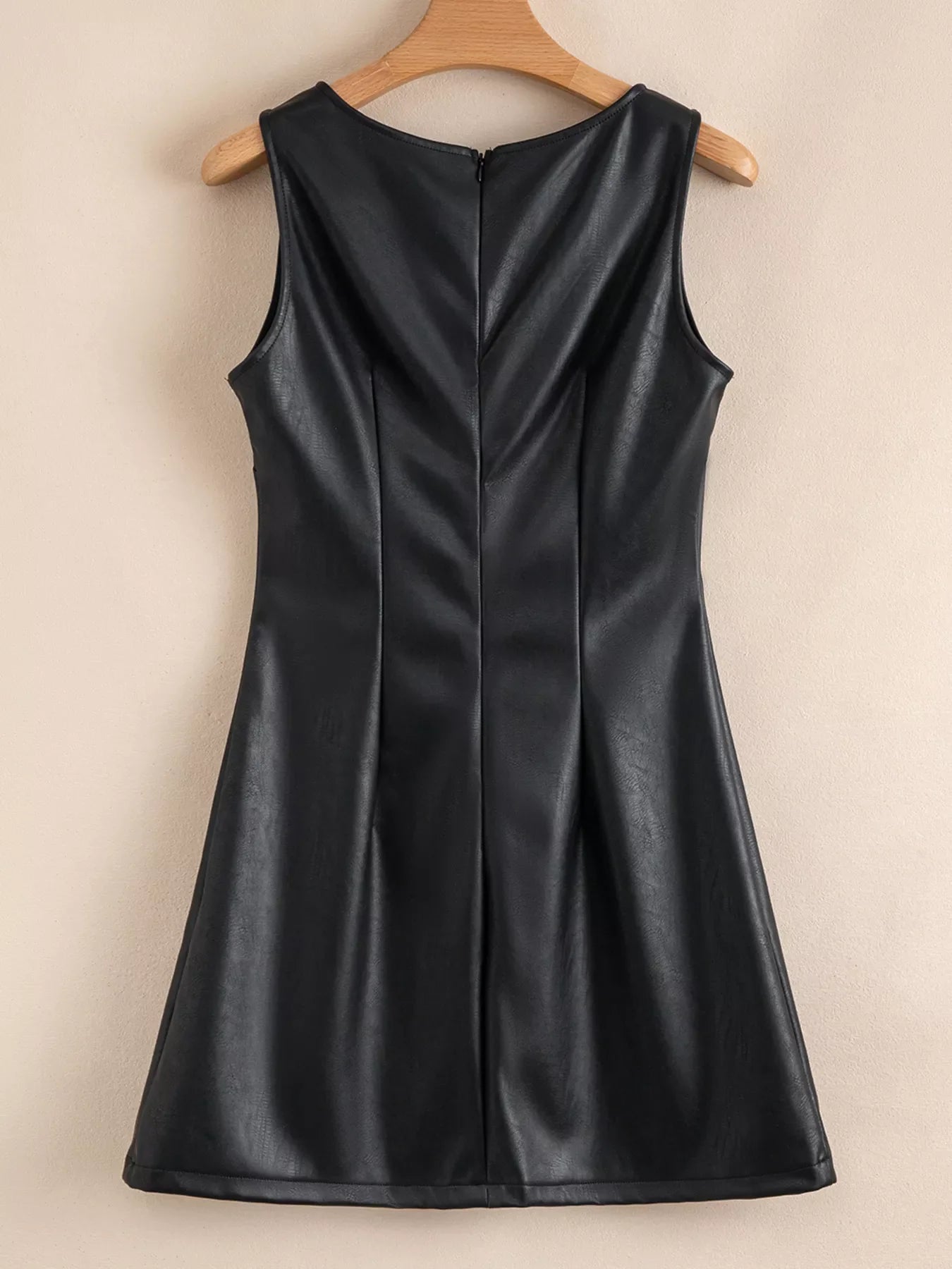 Black vegan leather sleeveless mini dress with a V-neck and a back zipper.
