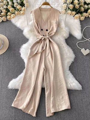 Chic V-neck wide leg jumpsuit in apricot with double-button detail and tie waist.