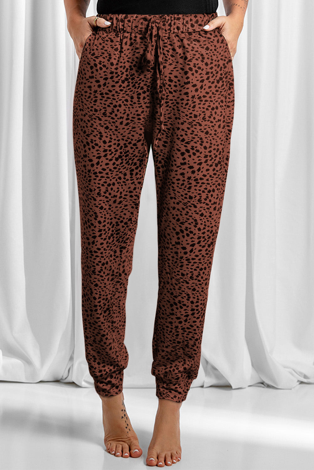 Brown leopard print joggers with drawstring waist and cuffed ankles.