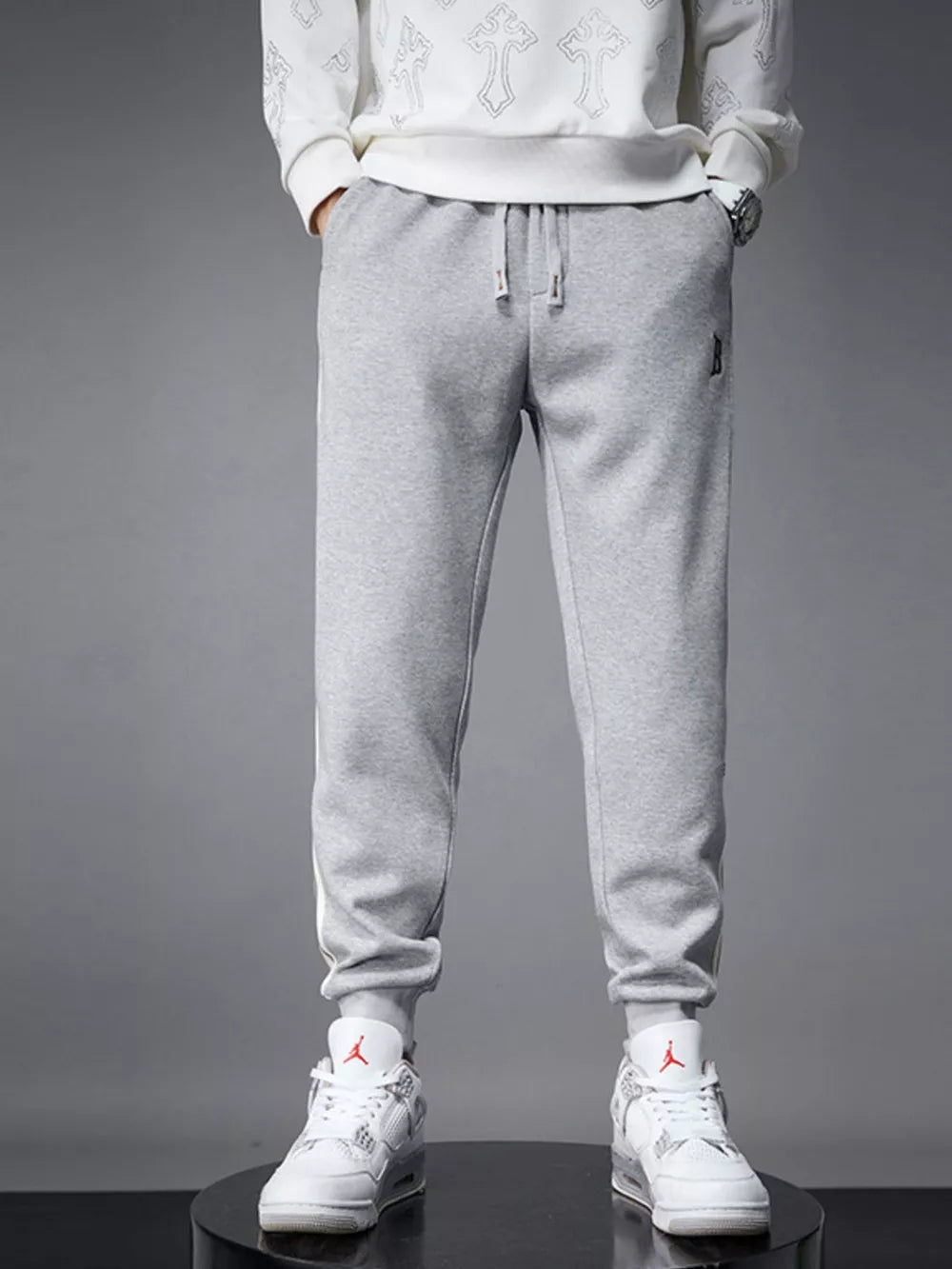 Light gray cotton joggers with drawstring and cuffed hem.