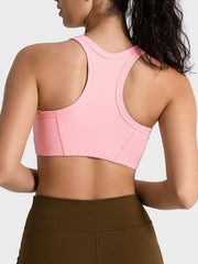 Ribbed blush pink racerback crop top with contour stitching and a racerback design.
