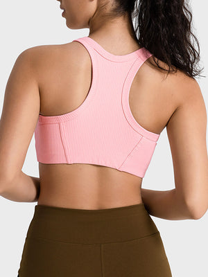 Ribbed blush pink racerback crop top with contour stitching and a racerback design.