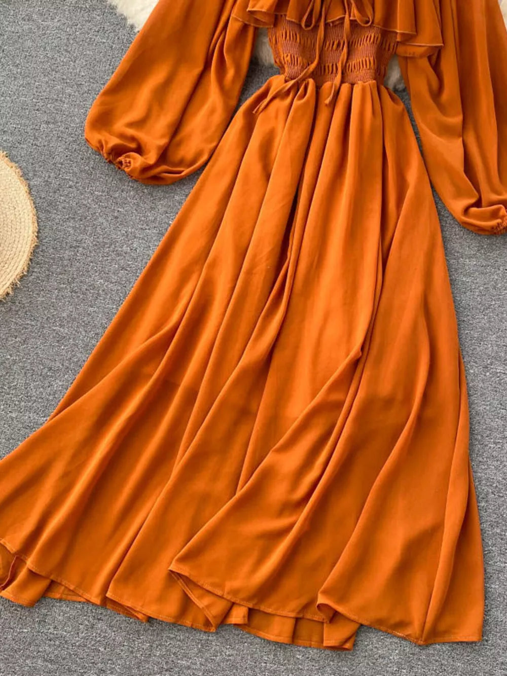 Orange ruffled square neck maternity dress with balloon sleeves and smocked bodice.
