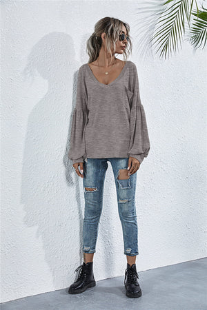 Dark gray knit top with V-neck, blouson sleeves, and chest pocket.