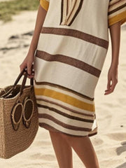 Striped half sleeve midi dress with brown and yellow stripes, styled with a straw tote bag.