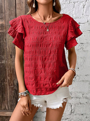Red textured smocked blouse with ruffle sleeves and a round neckline.