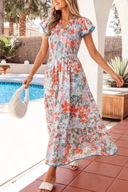 Vibrant floral maxi dress with flutter sleeves, smocked bodice, and tiered skirt.