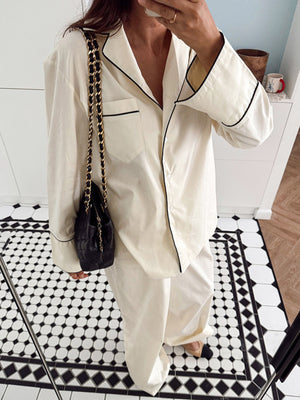 Cream button-up pajama set with black piping, long sleeves, and a pocket.