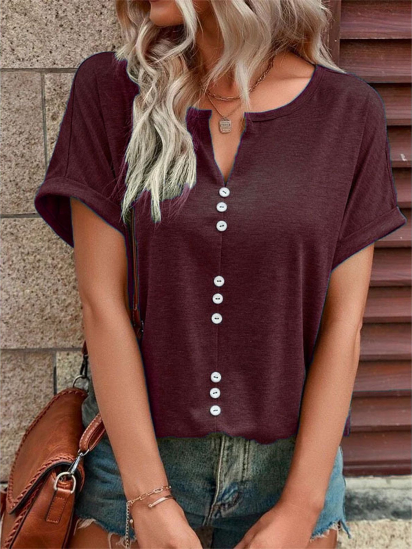 Buttoned V-neck short sleeve t-shirt in dark red with decorative buttons.