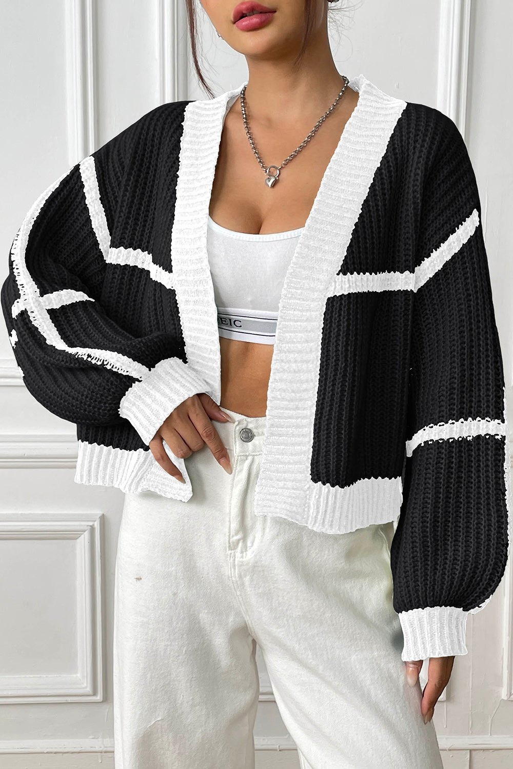 Black and white colorblock ribbed open cardigan with white trim and balloon sleeves.