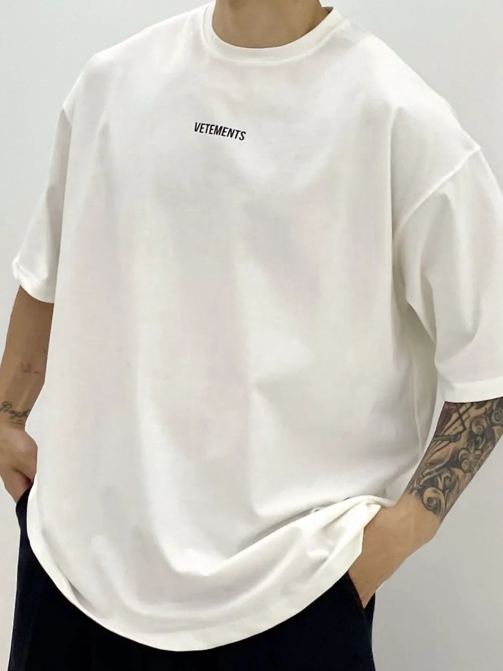 White oversized t-shirt with black VETEMENTS logo on chest.