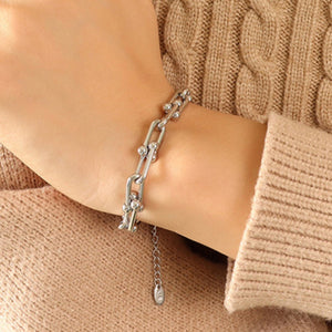 Silver sculptural link chain bracelet with beaded accents and adjustable extender.