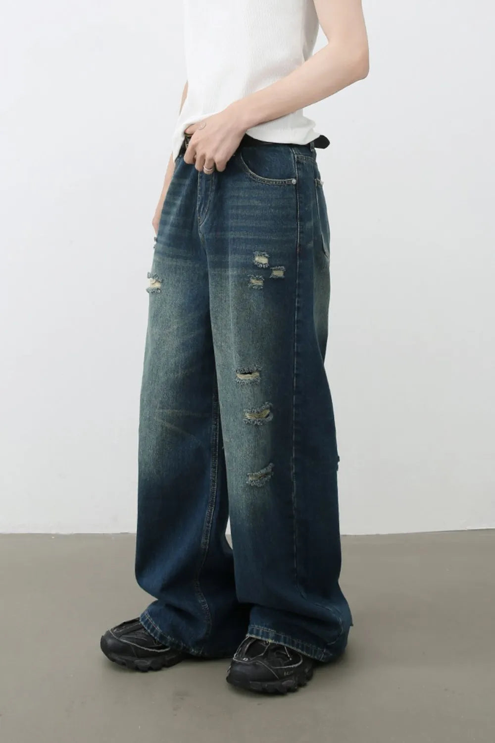Distressed baggy denim jeans in dark wash with ripped details.