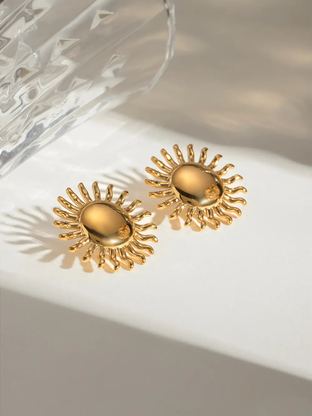 Gold sun stud earrings with sculptural rays, 18K gold-plated.