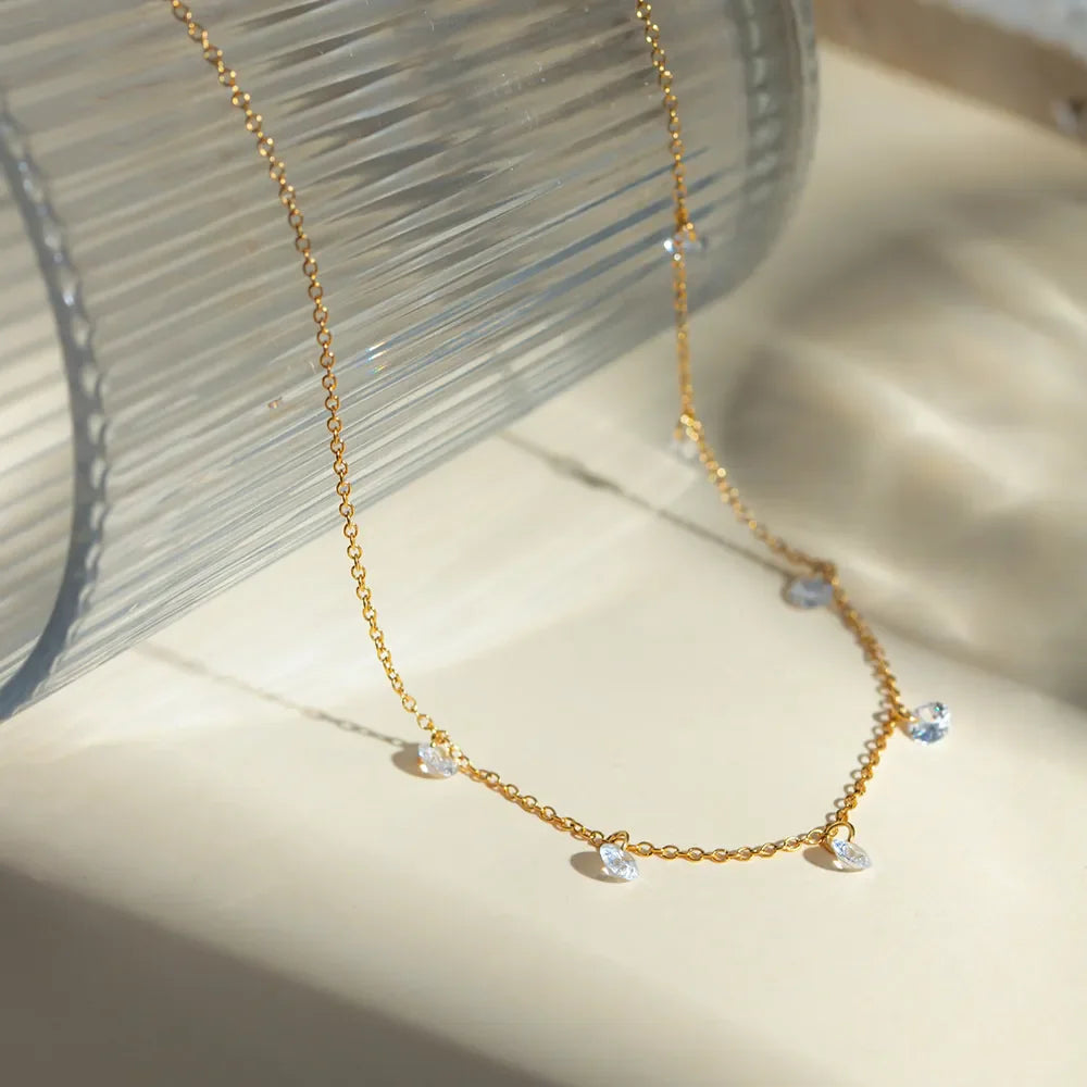 Gold dangling crystal station necklace with delicate chain and sparkling accents.
