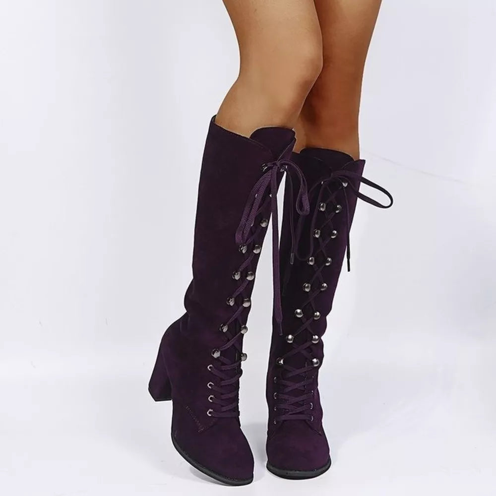 Purple suede lace-up block heel boots with silver eyelets and ties.