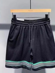 Black drawstring shorts with textured fabric and a patterned hem