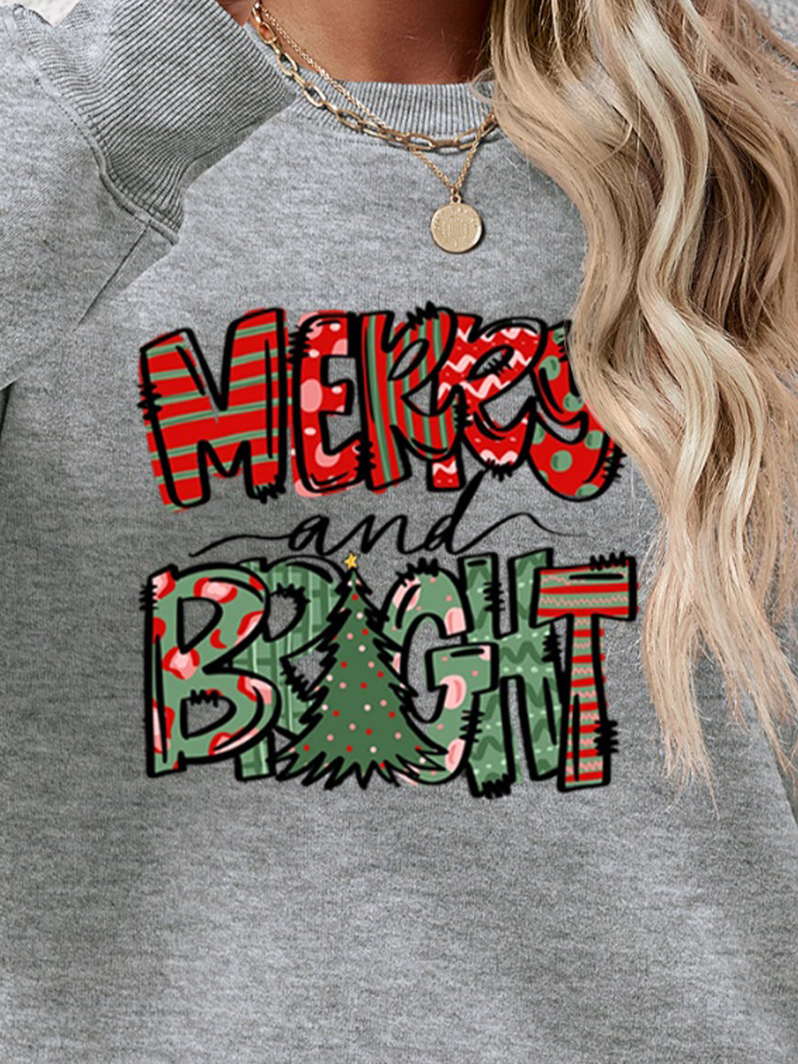 Crewneck sweatshirt with Merry and Bright Christmas graphic in red and green patterns.