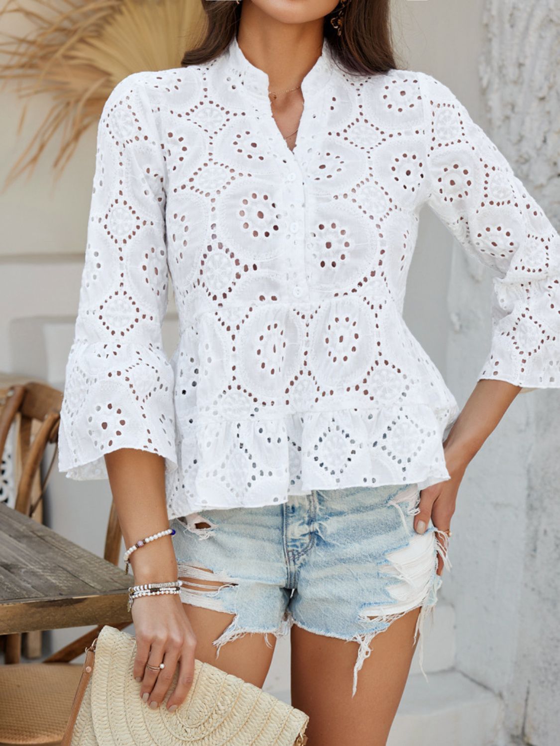 White eyelet embroidered peplum blouse with ruffles and bell sleeves.