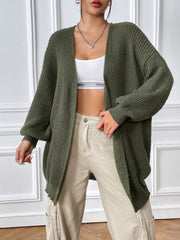 Olive green ribbed knit cardigan with balloon sleeves and an open front, styled with a white crop top and beige pants.