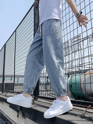 Light blue relaxed fit drawstring waist jeans with cuffed ankles.