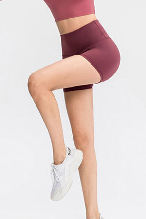 Burgundy athletic shorts with a high waist and seamless contour detail.