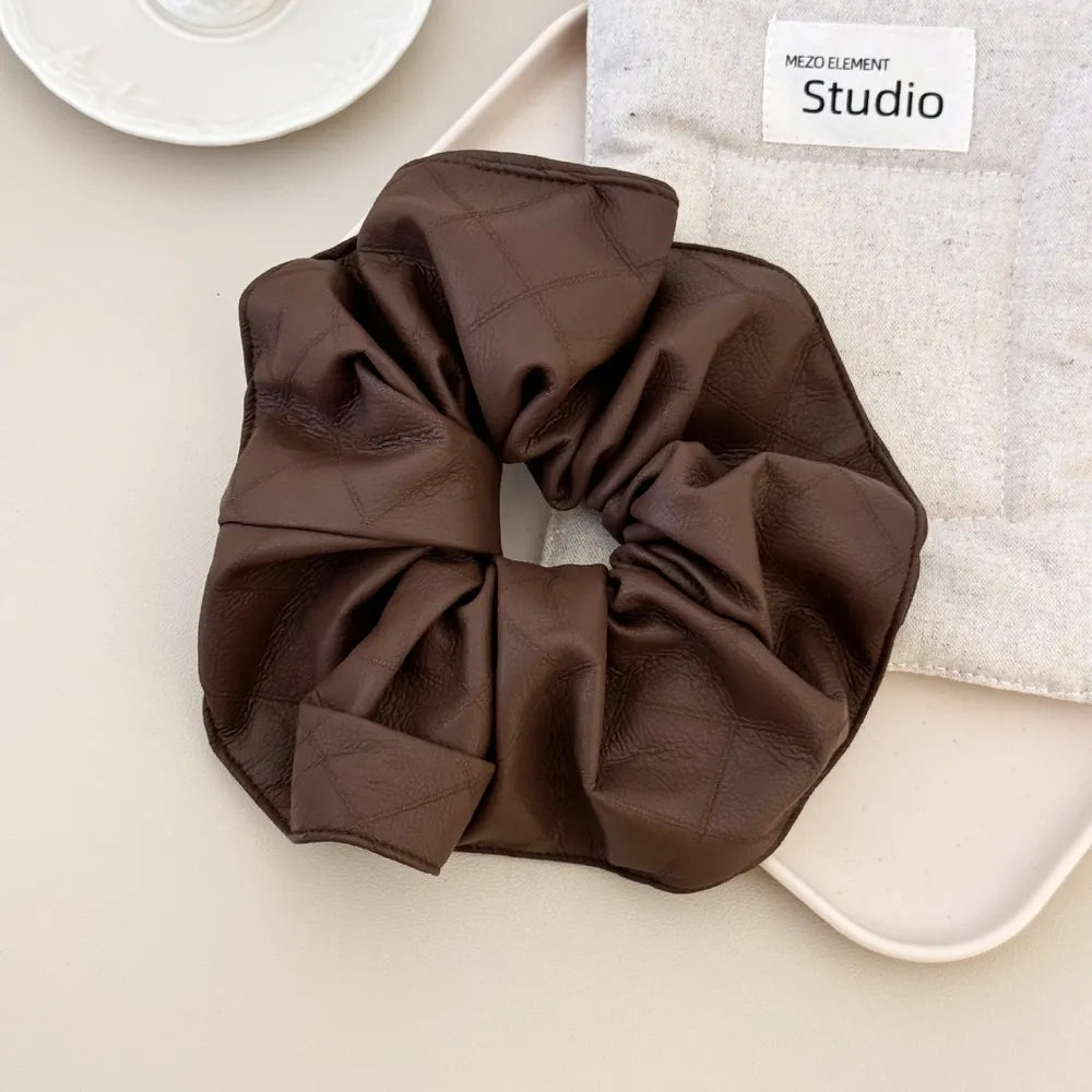 Brown quilted faux leather scrunchie with a bow detail.